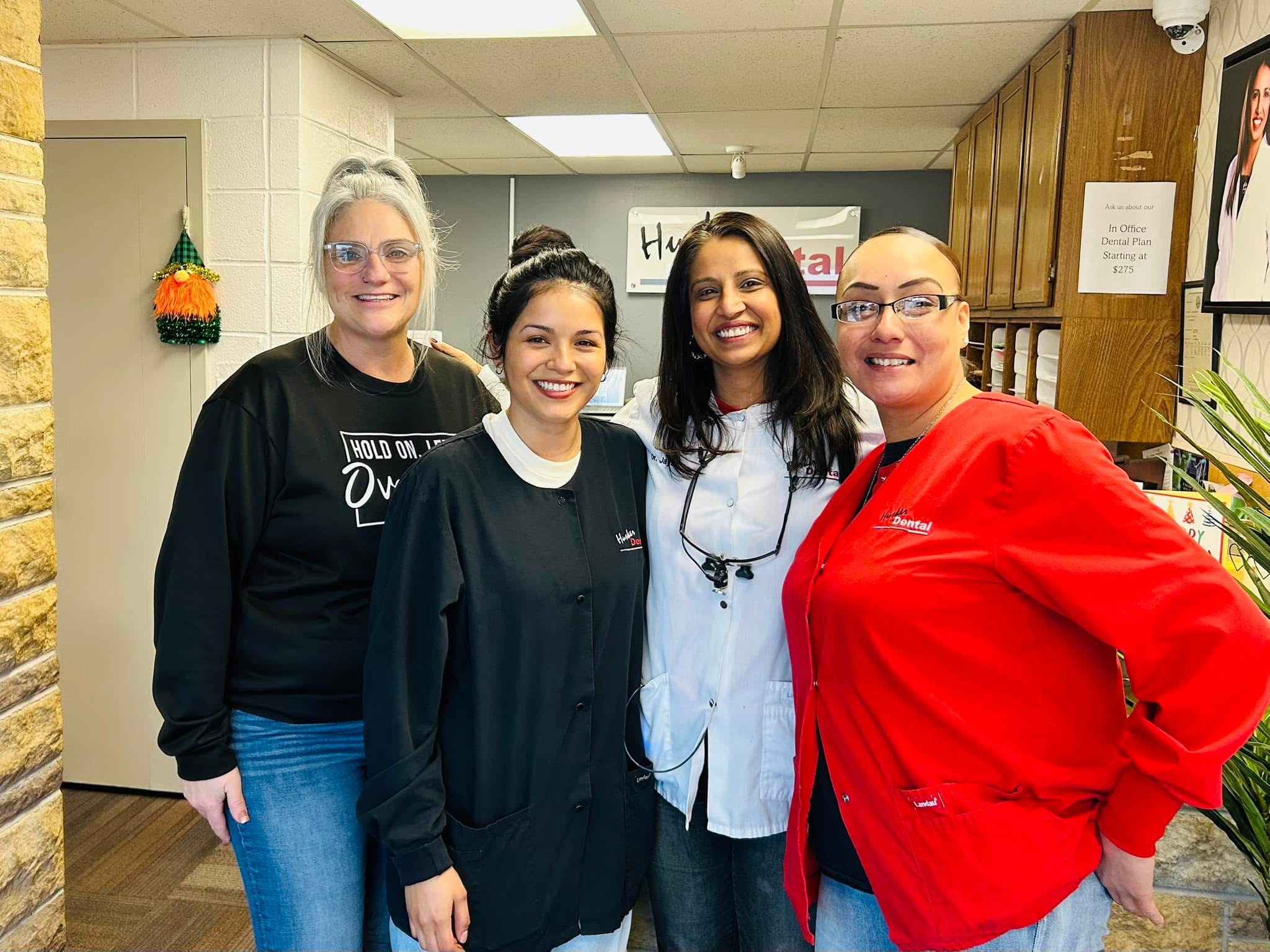 Friendly Husker Dental team smiling together in the office